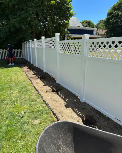 Fresh-cut bed edge along a vinyl fence