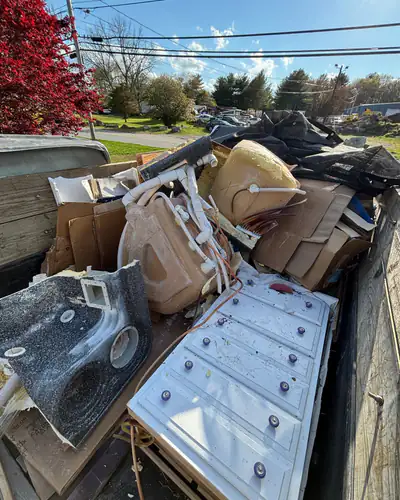 Trailer loaded with a dresser, a spa shell and boxes