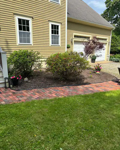 Before: bare bed along the brick walk