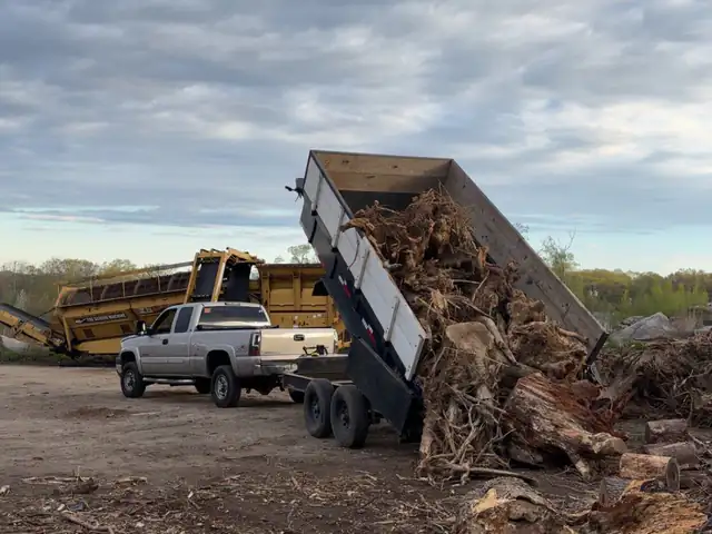 Dumping a trailer of stumps and brush